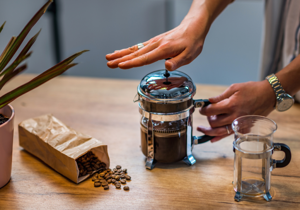 Man using a French press brewing coffee machine